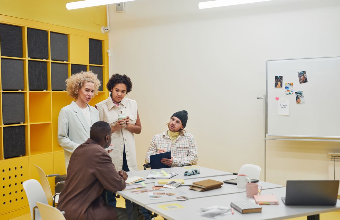 Junges, vielfältiges Team bespricht in einem hellen, modernen Büro die Arbeitgebermarke des Unternehmens