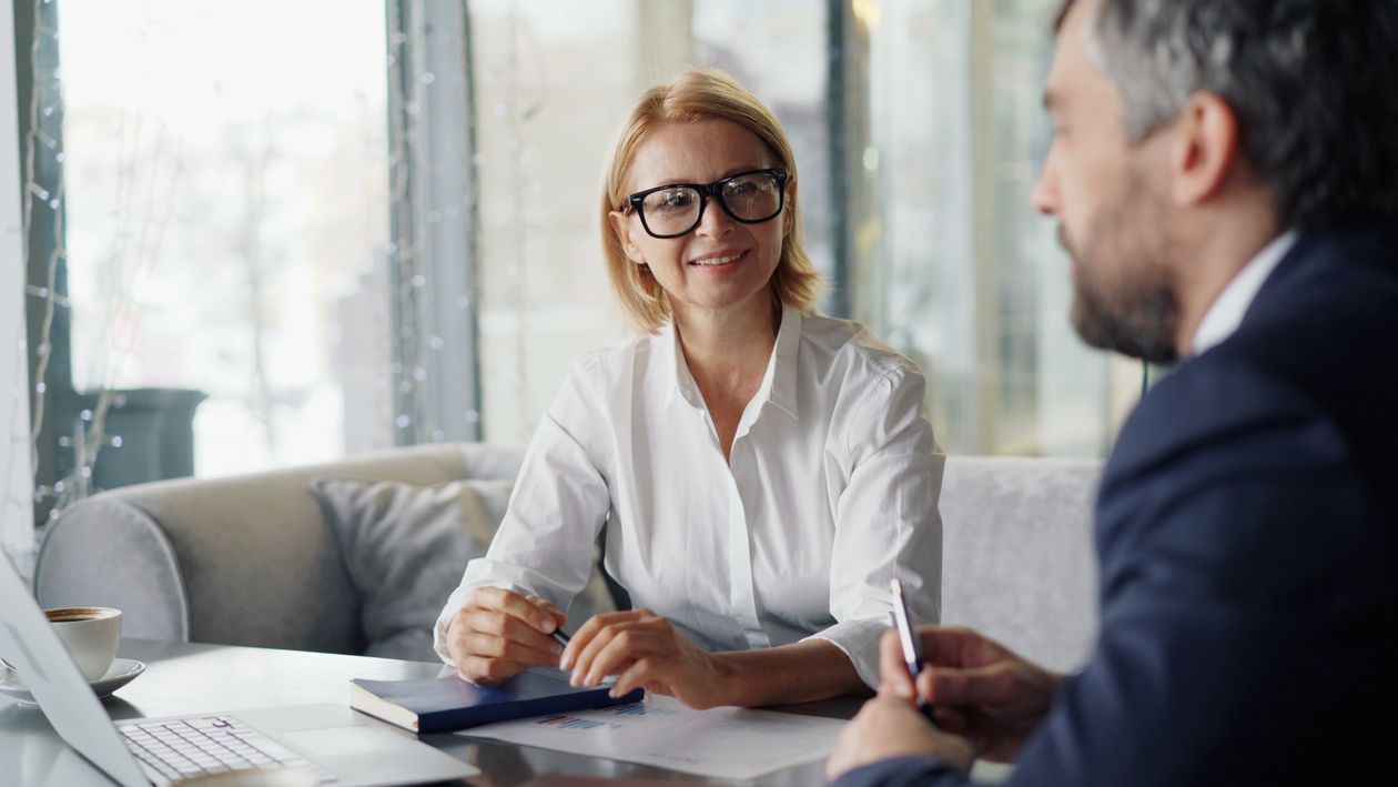 Geschäftsführerin und Führungskraft im Entwicklungsgespräch an einem Besprechungstisch
