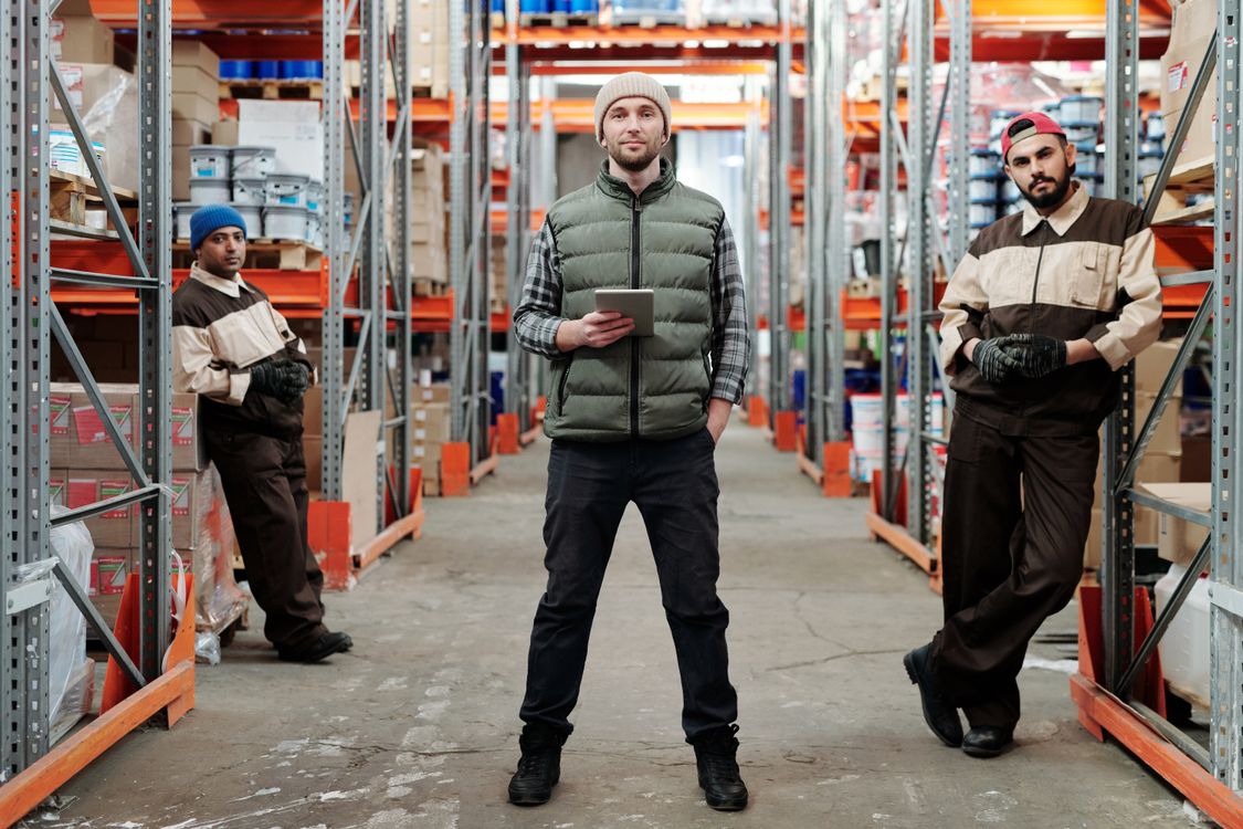 Einkaufs- und Lagerteam im Materiallager eines Industrieunternehmens bespricht Bestände am Tablet