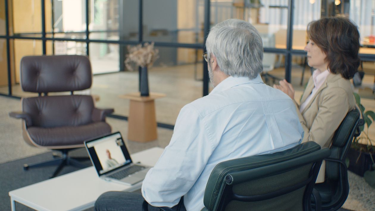 Zwei erfahrene Führungskräfte sprechen im Büro per Videokonferenz mit einem Teammitglied