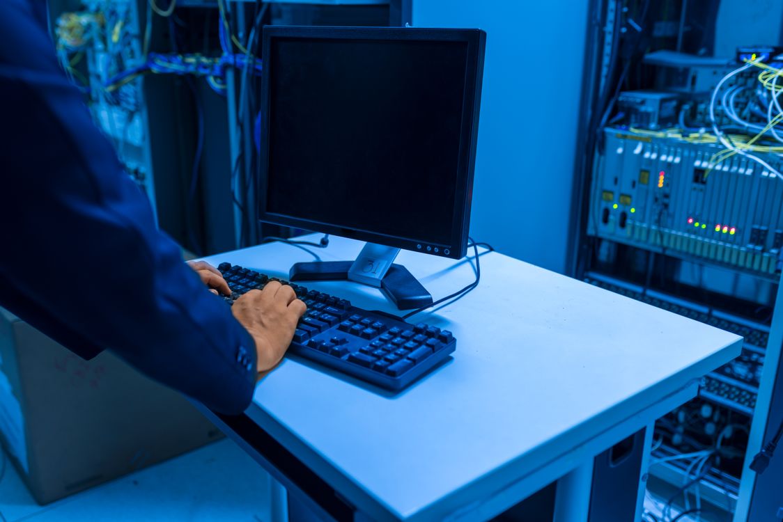 IT-Verantwortlicher arbeitet an einem Terminal im Serverraum eines mittelständischen Unternehmens